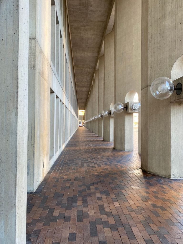view looking down a row of concrete pillars and lights at the Christian Science Center Boston