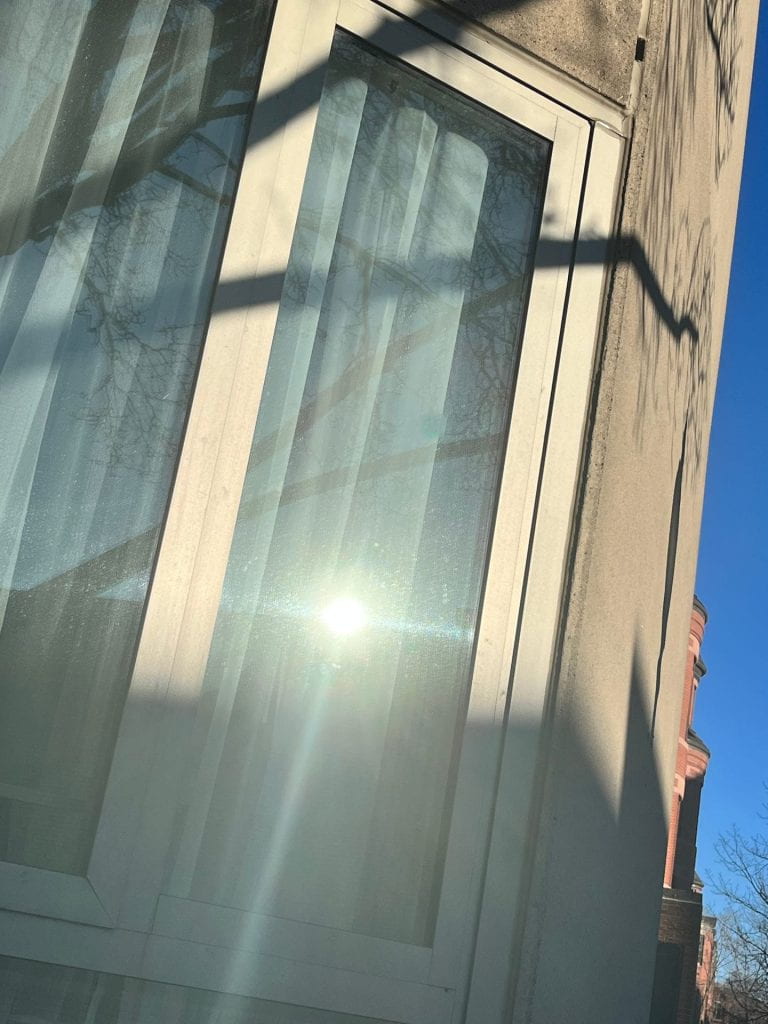 reflective window in a concrete building with sun shining on it