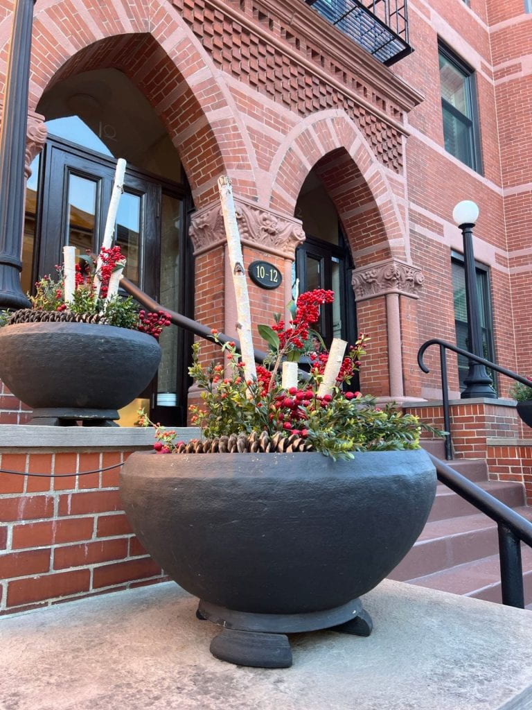large planters with flowers in front of brick arches in a brick building