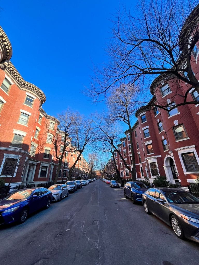 wide angle shot of a Boston city street with brick buildings and cars